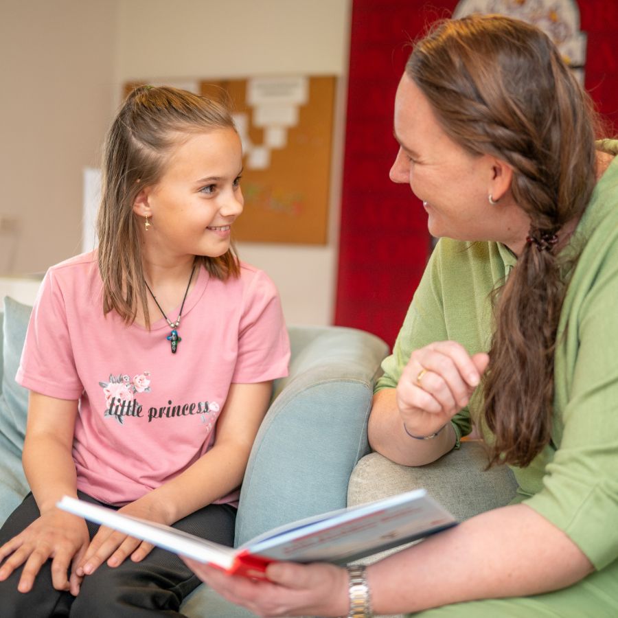 Eine Frau ließt ein Buch mit einem Mädchen