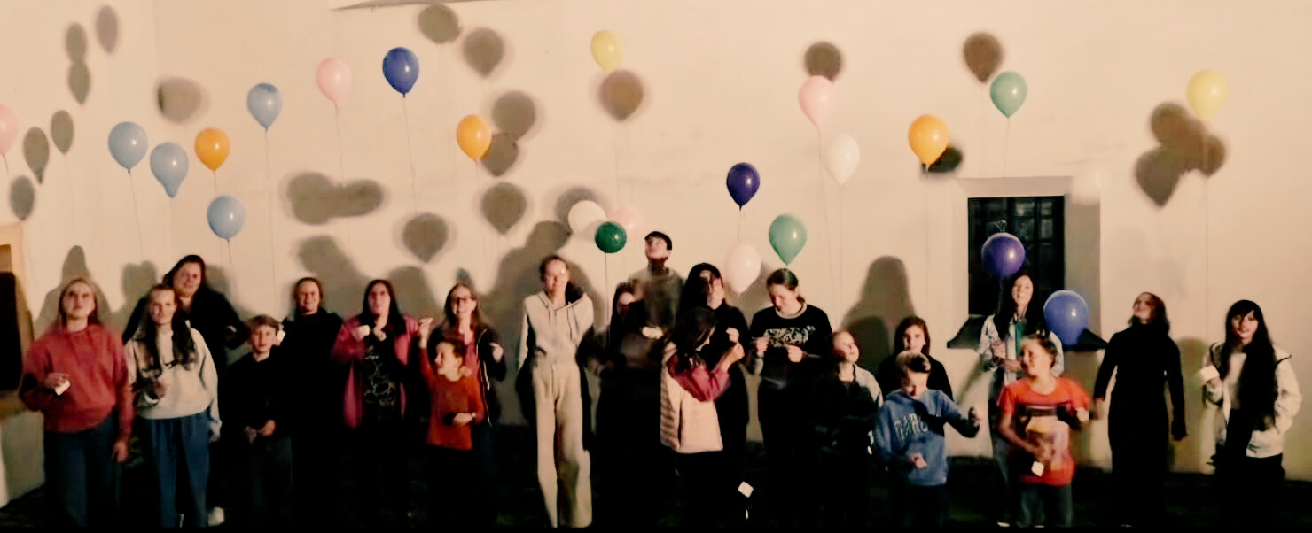 Jugendliche lassen vor der Kirche Luftballons steigen
