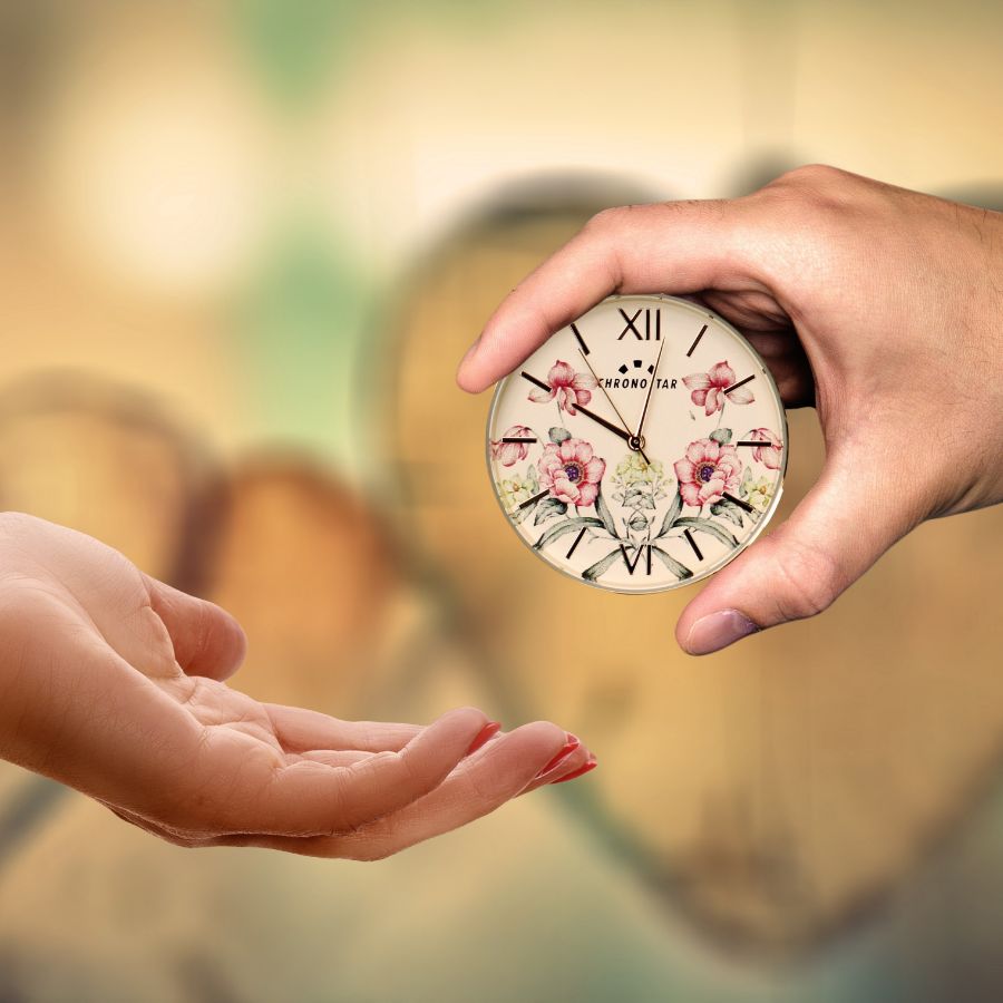 Zwei Hände schenken einander eine Uhr